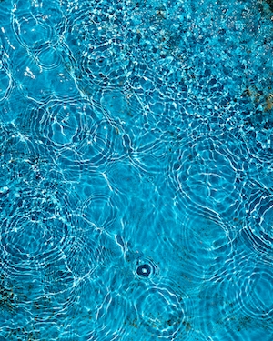 Рябь на поверхности воды в свежем голубом бассейне летом.