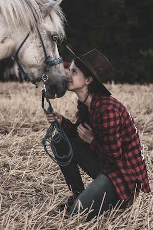 фотосессия девушки в шляпе с белым конем 
