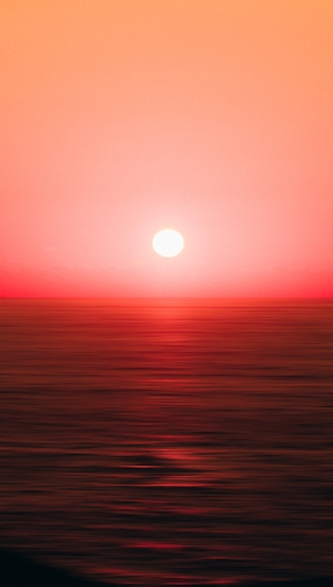 большое яркое солнце и красное небо вокруг него, закат над морем 