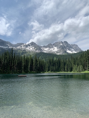 Горное озеро, отражение неба и гор в воде, лесу у озера и гор 