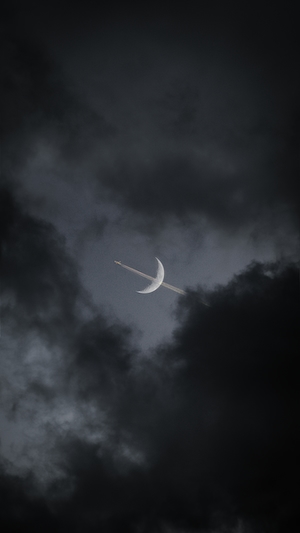 полумесяц на темном небе, облака и пролетающий самолет 