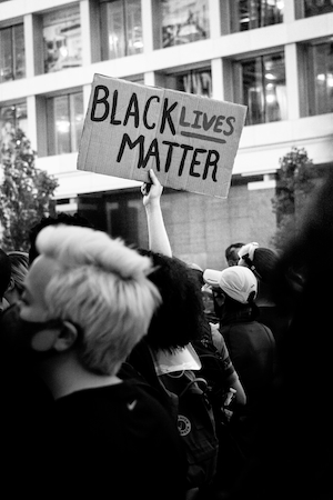 "жизни темнокожих имеют значение", черно-белая фотография плаката на митинге 
