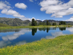 Горное озеро, отражение неба и гор в воде, лес у озера и гор