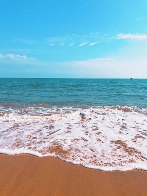 песчаный пляж днем, голубое небо и море 