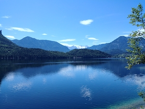 Горное озеро, отражение неба и гор в воде, лес у озера и гор