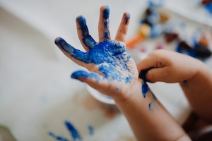 испачканные синими красками детские руки 