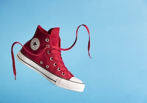 Снимок продукта Red Converse All Star, красный кроссовок на голубом фоне 