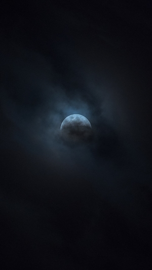 луна на темном небе в облаках 