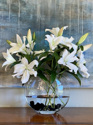 Белые восточные лилии в стеклянной вазе 