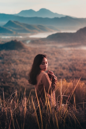 закат в горах, облака, девушка фотографируется в поле 