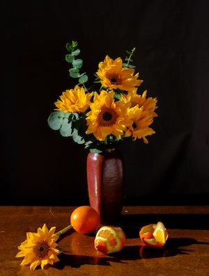 подсолнухи в вазе, апельсины на столе 
