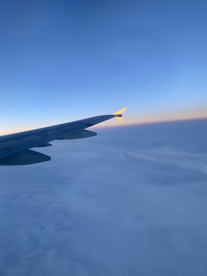 Фото крыла самолета из окна иллюминатора, облака 
