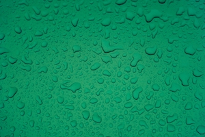 Капли дождя на зеленой металлической поверхности