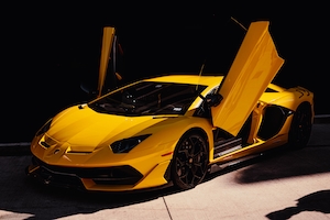 Желтый Lamborghini Aventador SVJ в тени с открытыми дверьми 
