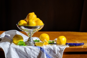 лимоны в вазе, полотенца и нож 