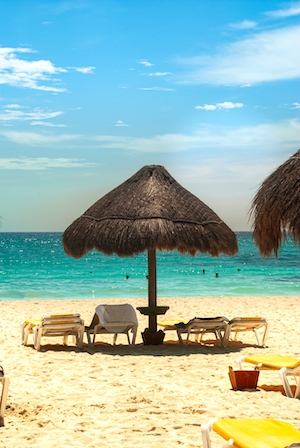 лежаки на песчаном пляже, соломенный зонт, бирюзовая вода 