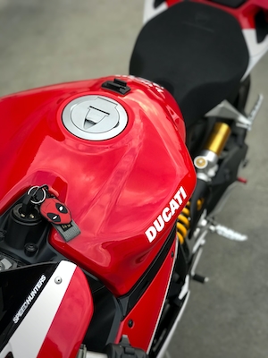 красный мотоцикл с ключами, на которых есть брелок в виде дэдпула 