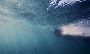 Погружение, парень в маске плавает под водой 