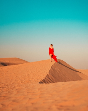 Девушка, идущая по пустынным дюнам Дубая