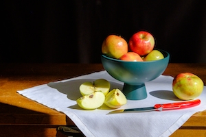 Натюрморт, яблоки на столе и в чашке 