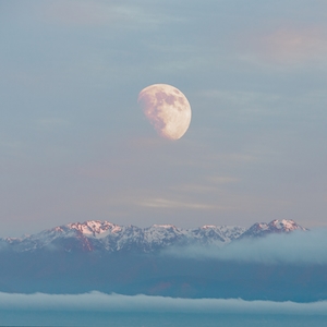 полная луна на небе во время заката в окружении облаков над горами 