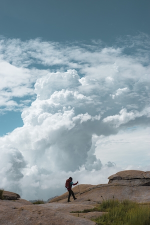 турист в горах на фоне облаков 