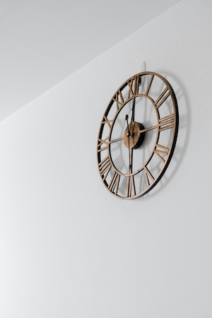 часы с римскими цифрами на белой стене 
