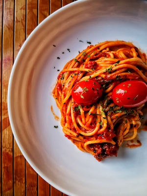 спагетти болоньезе с помидорами черри на тарелке, крупный план