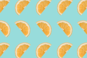Ломтики цитрусовых, половинки апельсина на пастельно-голубом фоне. 