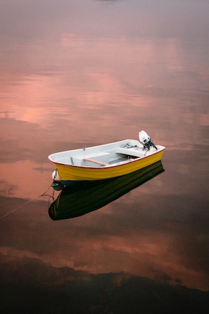 лодка на тихой воде во время заката 