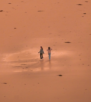 две девушки гуляют по красному песку 