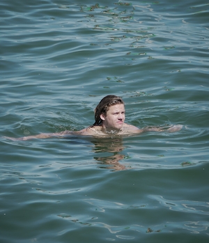 парень плывет в воде 