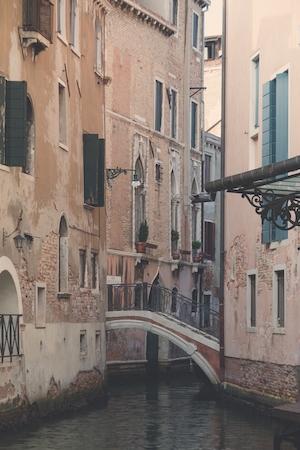 Узкий канал в Венеции днем, здания на воде, мостик