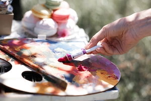 художник набирает краску с палитры 