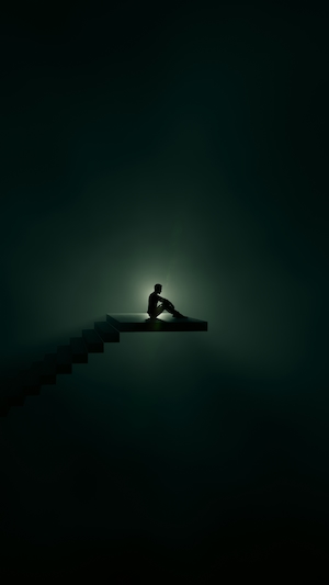человек сидит в темноте 