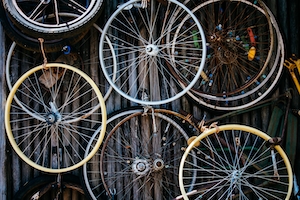 Коллекция старых велосипедных запчастей, висящих на стене.