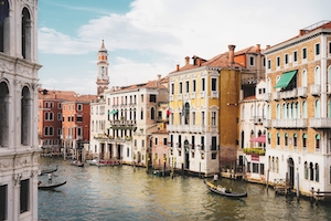 Канал в Венеции днем, здания на воде, гондола с гондольером 