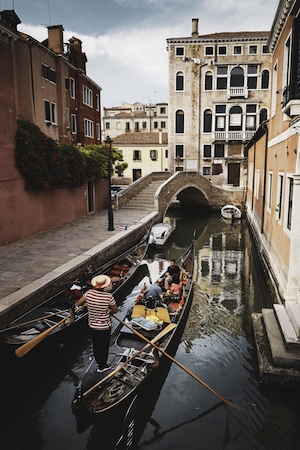 Канал в Венеции днем, здания на воде, гондола с гондольером