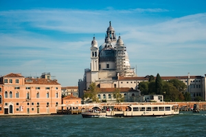 Канал в Венеции днем, здания на воде, туристические лодки 